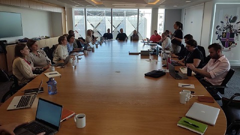 A group seated around a table for a discussion meeting.