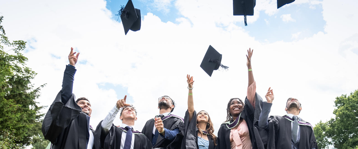 graduates throwing their caps into the air