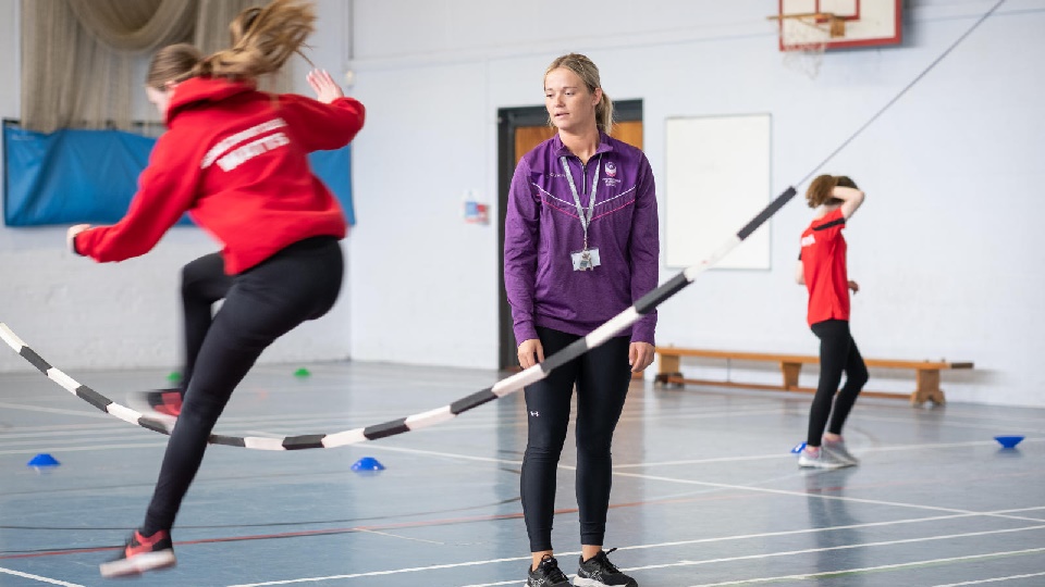 A PGCE Physical Education student on placement in school is teaching children PE