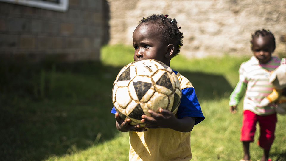 Child holding a football. Photo credit: The African Population and Health Research Center (APHRC) and Loughborough University