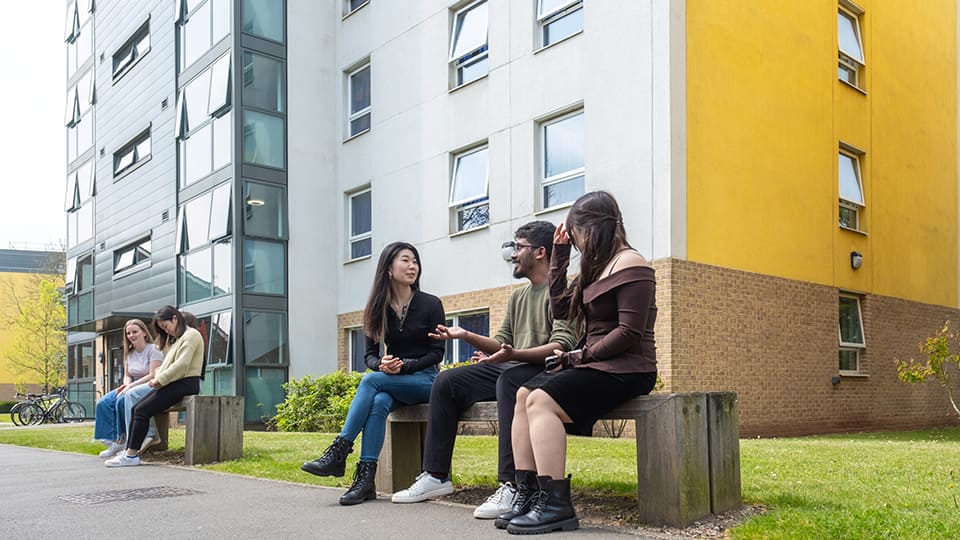 Students sat together outside of John Phillips postgraduate student accommodation at Loughborough University