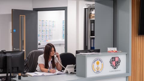 Toni answering the phone on the Cayley / Claudia Parsons Reception desk