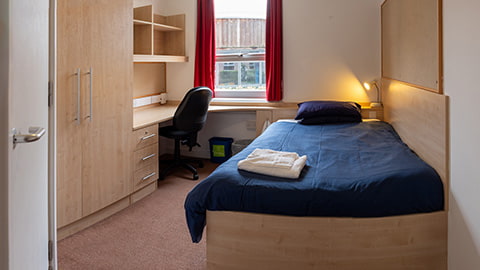 Modern and sophisticated student accommodation in Elvyn Richards catered halls of residence. Large 4ft bed with spacious study desk, wardrobe and shelving.