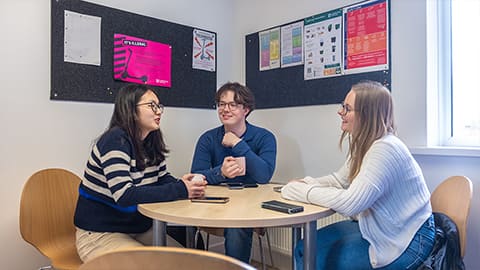Three students sat together at the kitchen table at Falkner Eggington halls of residence.