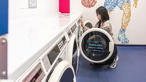 Student using a washing machine in the Falkner Eggington laundrette facilities