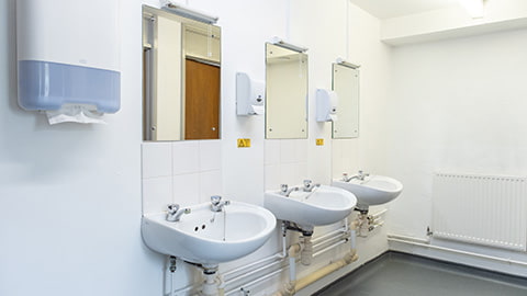 Group of three sinks and three mirrors in Faraday's shared bathroom facilities