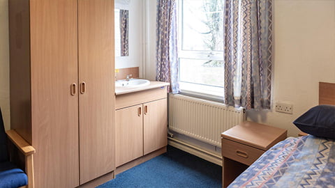 Corner of Faraday standard bedroom with cupboard and wash basin, out of the window students have a great view of campus.