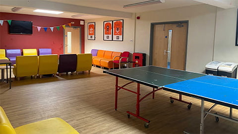 Common room social area with comfy seating options and table games in Faraday catered Loughborough hall of residence.
