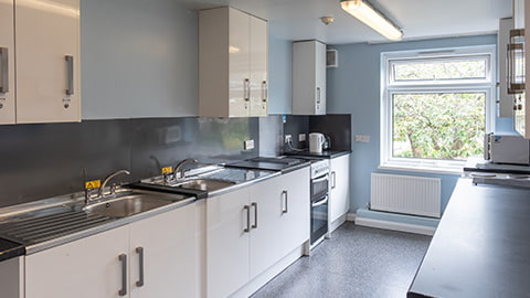 Cooking area in Faraday kitchen and dining space, with two ovens and hobs, fridges and lots of cupboard spaces for students.