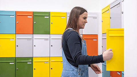 student collecting their post from Harry French reception brightly coloured postal area