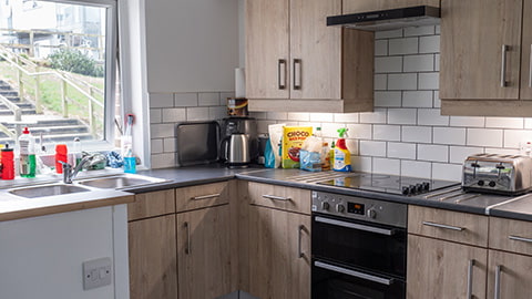 partial view of a kitchen in Robert Bakewell students accommodation, with ovens, fridge freezers and plenty of cupboard space.