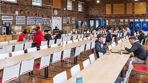 Students eating at long tables at Royce dining hall