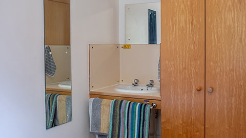 A hand wash basin and mirror in all standard Royce bedrooms