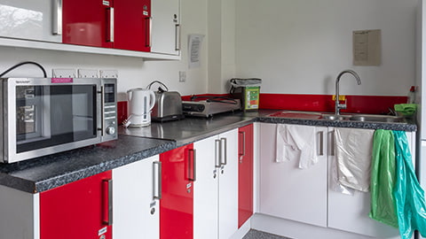 A standard small kitchen in Rutherford with microwave and storage space
