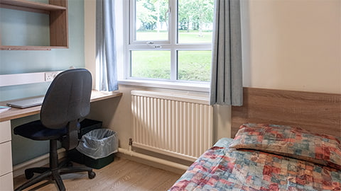 A standard bedroom in Telford student halls of residence with comfy bed, study desk and plenty of storage