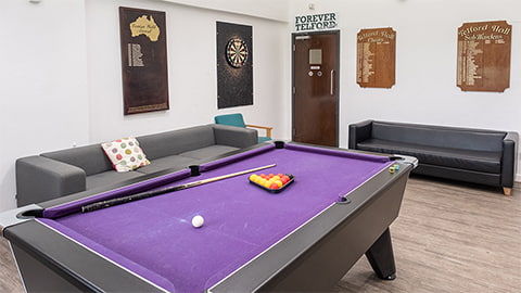 Telford common room with pool table and hall-related league tables and dart board hanging on the walls
