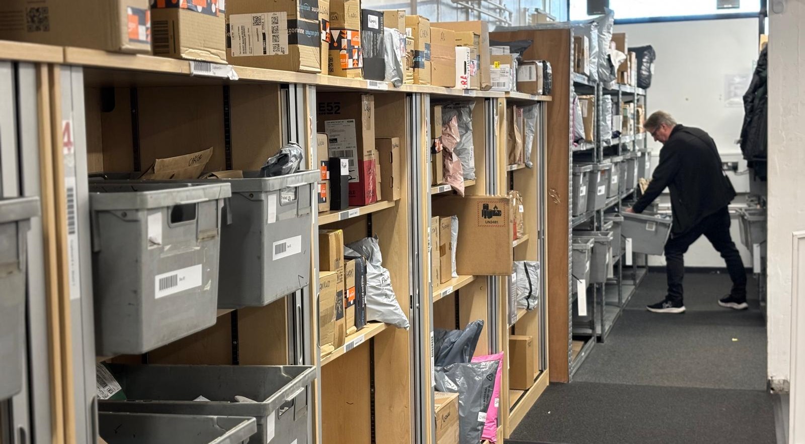 parcels on shelves, man finding parcel