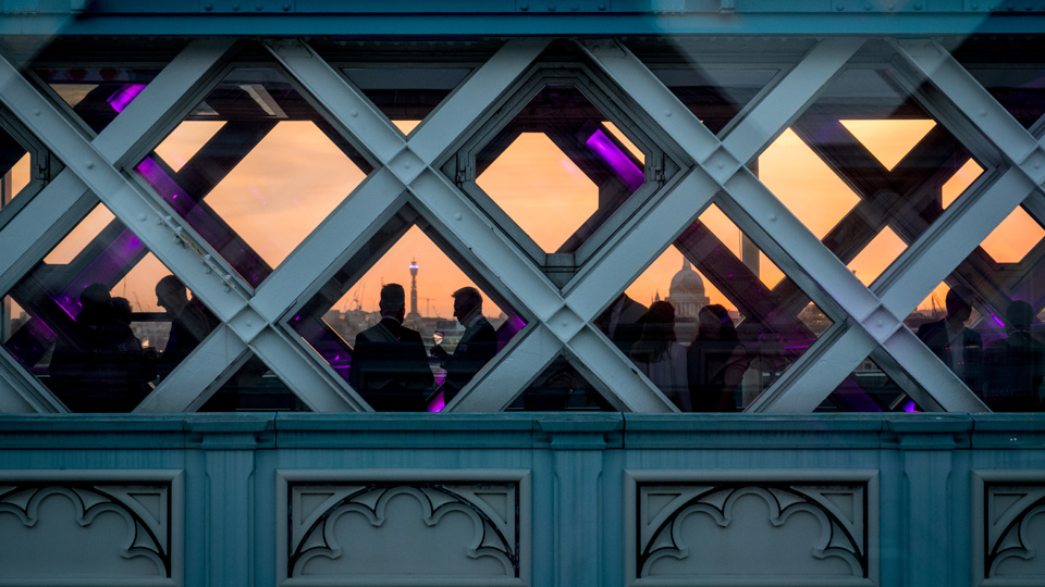 people on a bridge at sunset
