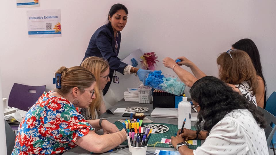 Summer showcase 2025 - a group of researchers working on a poster