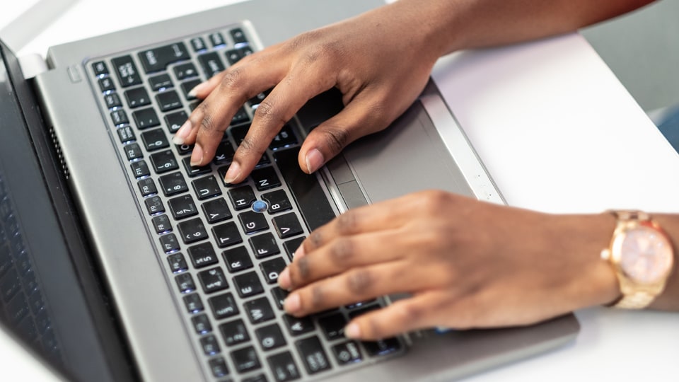A member of staff typing on a laptop
