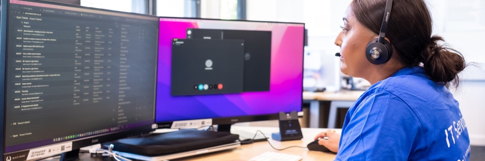 Member of staff on a support call with computer