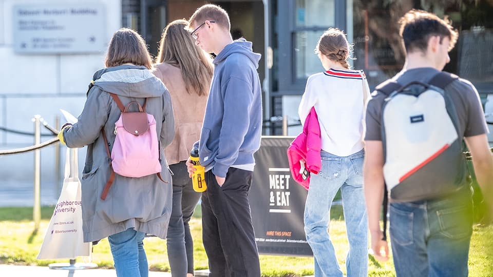 A group of students and parents outside on an open day
