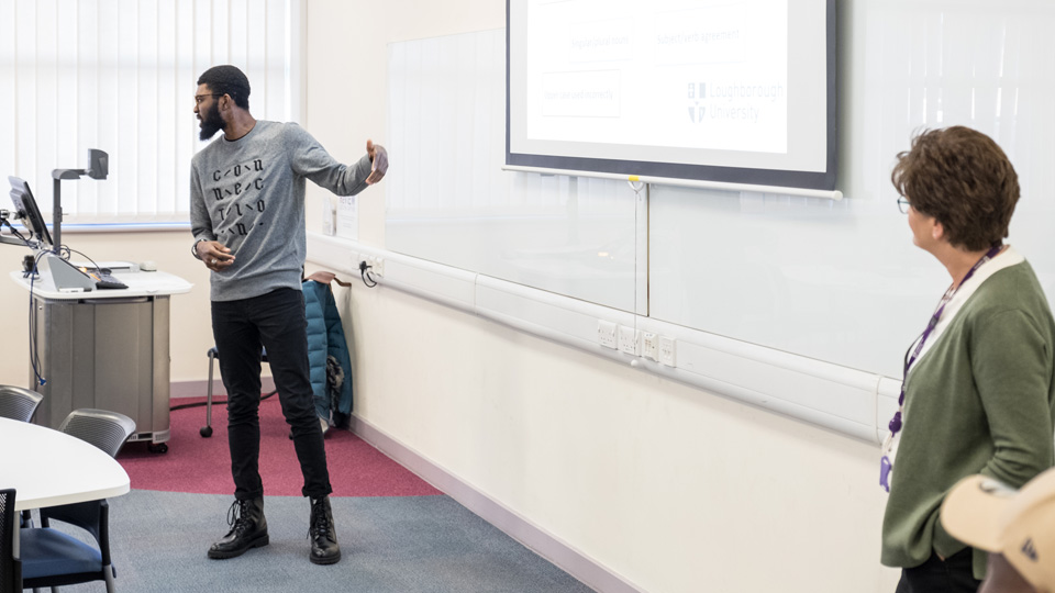 a lecturer pointing at his lecture slides