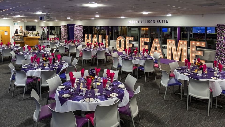 A room decorated for an event with set tables, decorations and lights