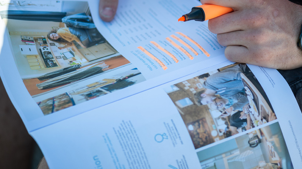 a man highlighting text in a printed brochure