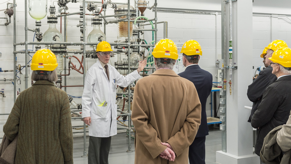 a group wearing protective clothing take a workshop tour