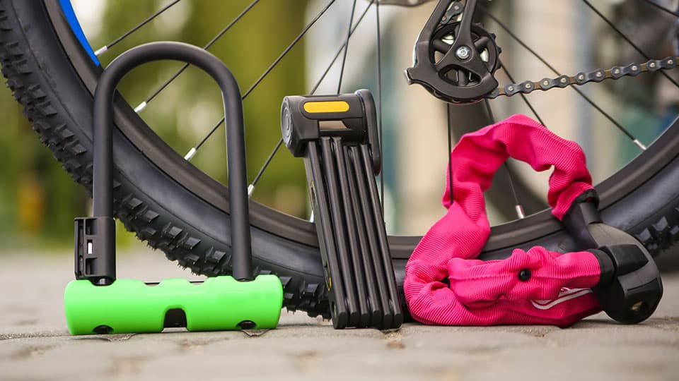 three bike locks leaning against a bicycle tyre