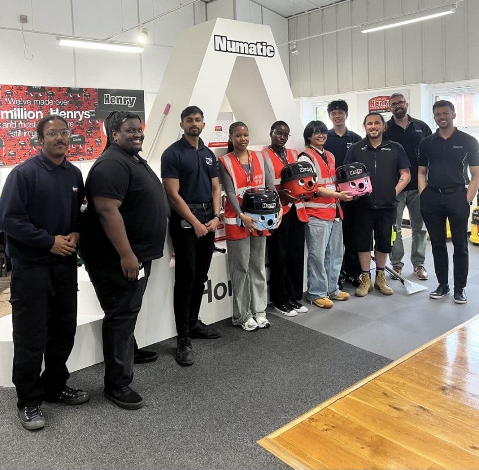 A group photo of 10 people from a Transition event, stood with Numatic vacuums