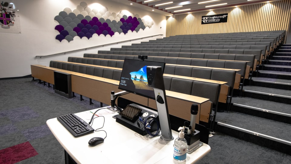 Edward Herbert Lecture EHB110a - hall with tiered seating, multimedia podium, and decorative wall panels. Sign reads 
