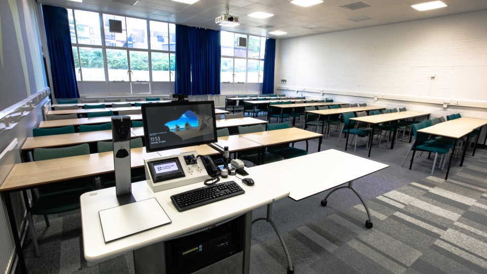Wavy Top WAV037 - Lecture theatre with rows of desks and chairs, large windows, blue curtains, and a teaching station with computer equipment.