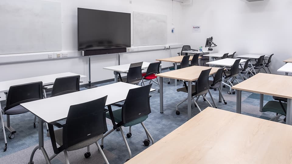 Wavy Top WAV044 - Classroom with rows of desks and chairs, large screen at the front, whiteboards on walls, and a computer station.