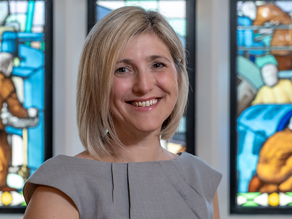 Portrait of Emma Keightley against a stained glass window