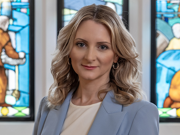 Portrait of Rebecca Cain against a stained glass window