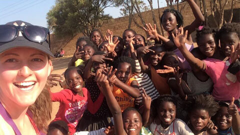 student with girls in zambia