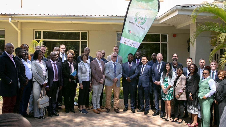 the group of delegates stood in a group outside of a building in zambia