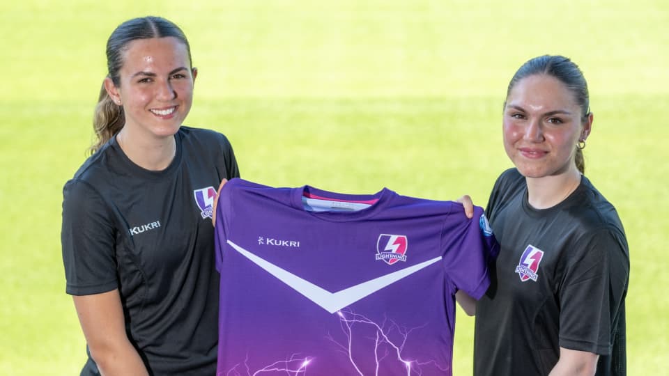 Two players holding a team t-shirt