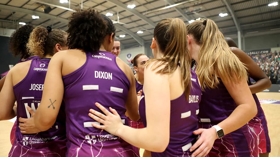the team on court with their backs to the camera