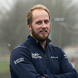 Jon wearing a Scottish Canoe Association jacket with his arms folded