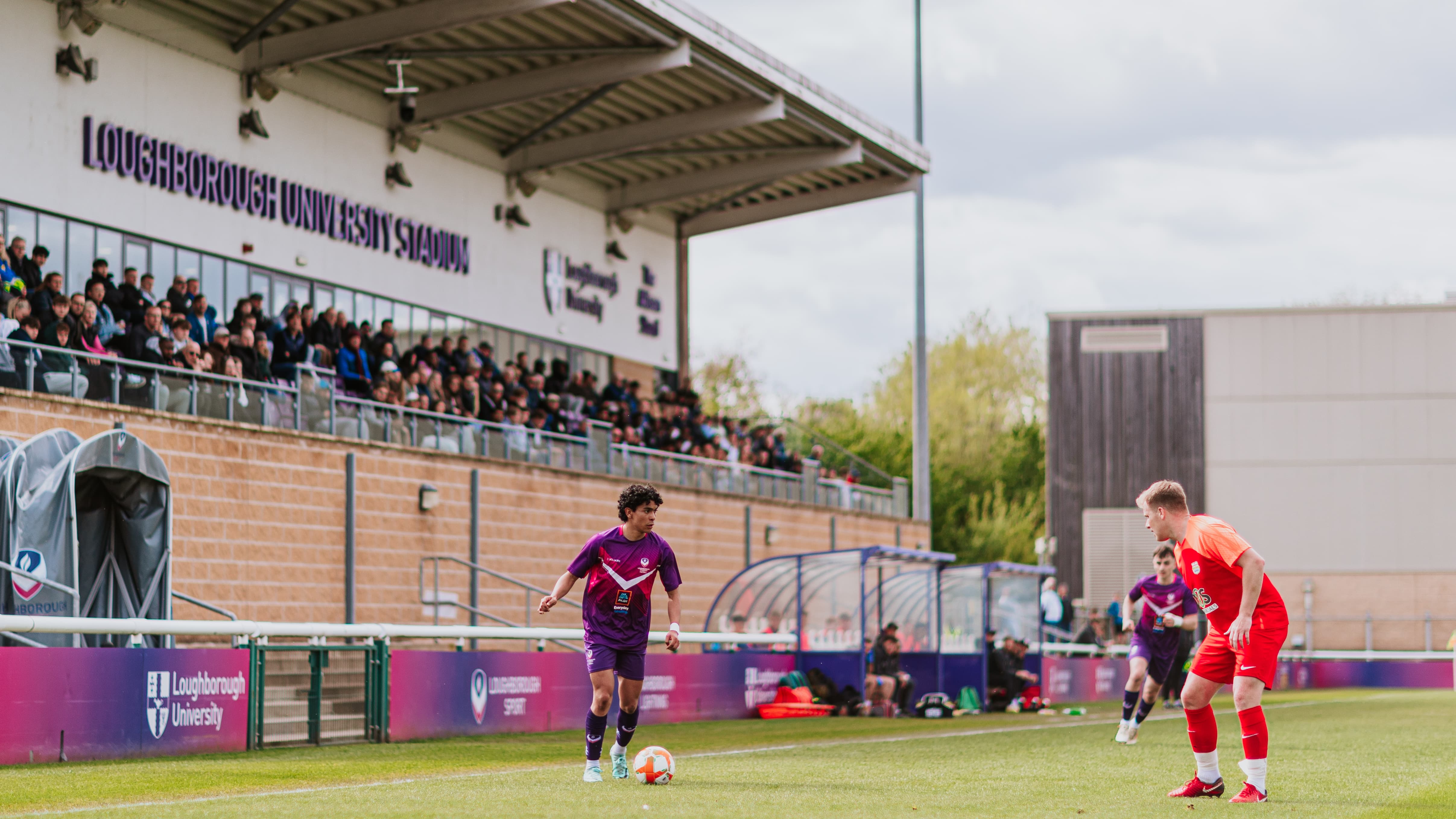 A Loughborough Students football with the ball on the pitch at the University Stadium