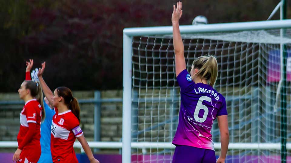 A Lightning football player standing on the pitch with back to the camera