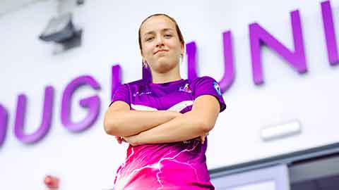 A Loughborough Lightning football player stood, looking into the camera with their arms folded