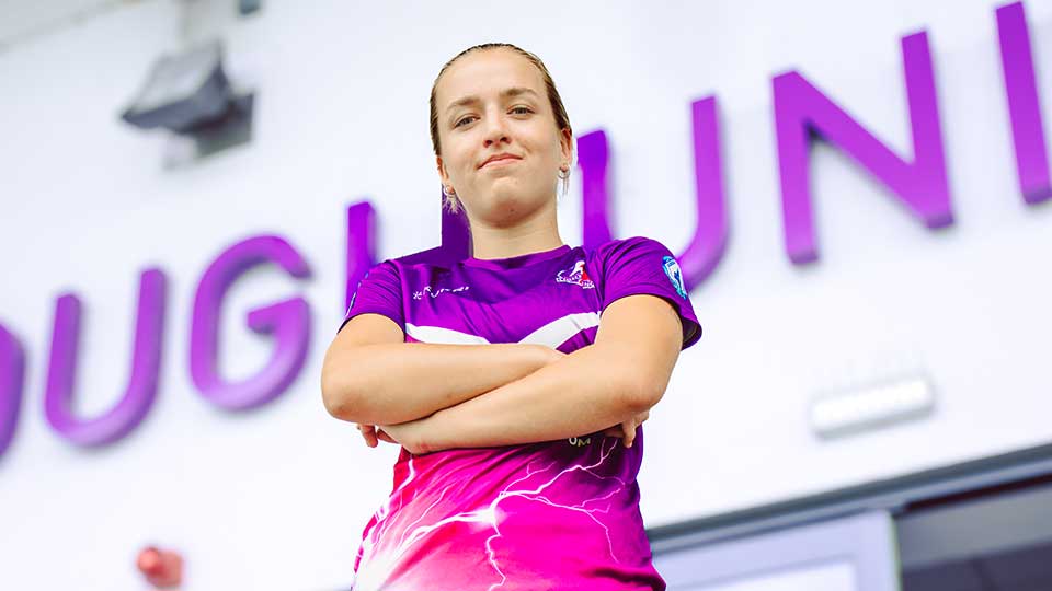 A Loughborough Lightning football player stood, looking into the camera with their arms folded