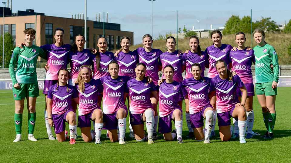 Lightning Football squad wearing kit, stood for a team photo on a football pitch.
