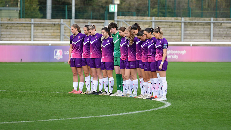 The team stood on a football pitch