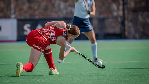 Amy Cradden on pitch pushing all ball with a hockey stick