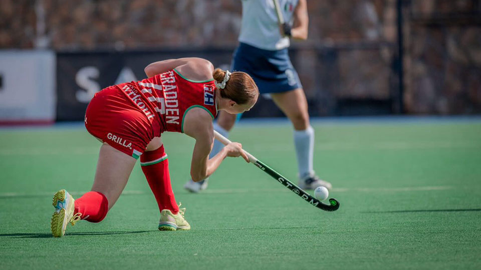 Amy Cradden on pitch pushing all ball with a hockey stick